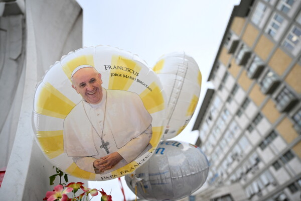 Balloons depicting Pope Francis are laid at the statue of John Paul II outside the Gemelli hospital where Pope Francis is hospitalized, in Rome on Monday.