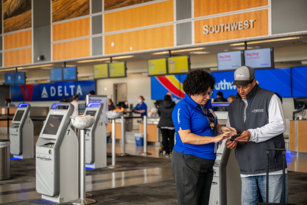 Southwest Airlines unveiled big shifts in how it does business Thursday, saying it will throw out the open-seating model it has used for decades and introduce redeye flights. Here, an employee and passenger are seen at the Austin-Bergstrom International Airport last year in Austin, Texas.