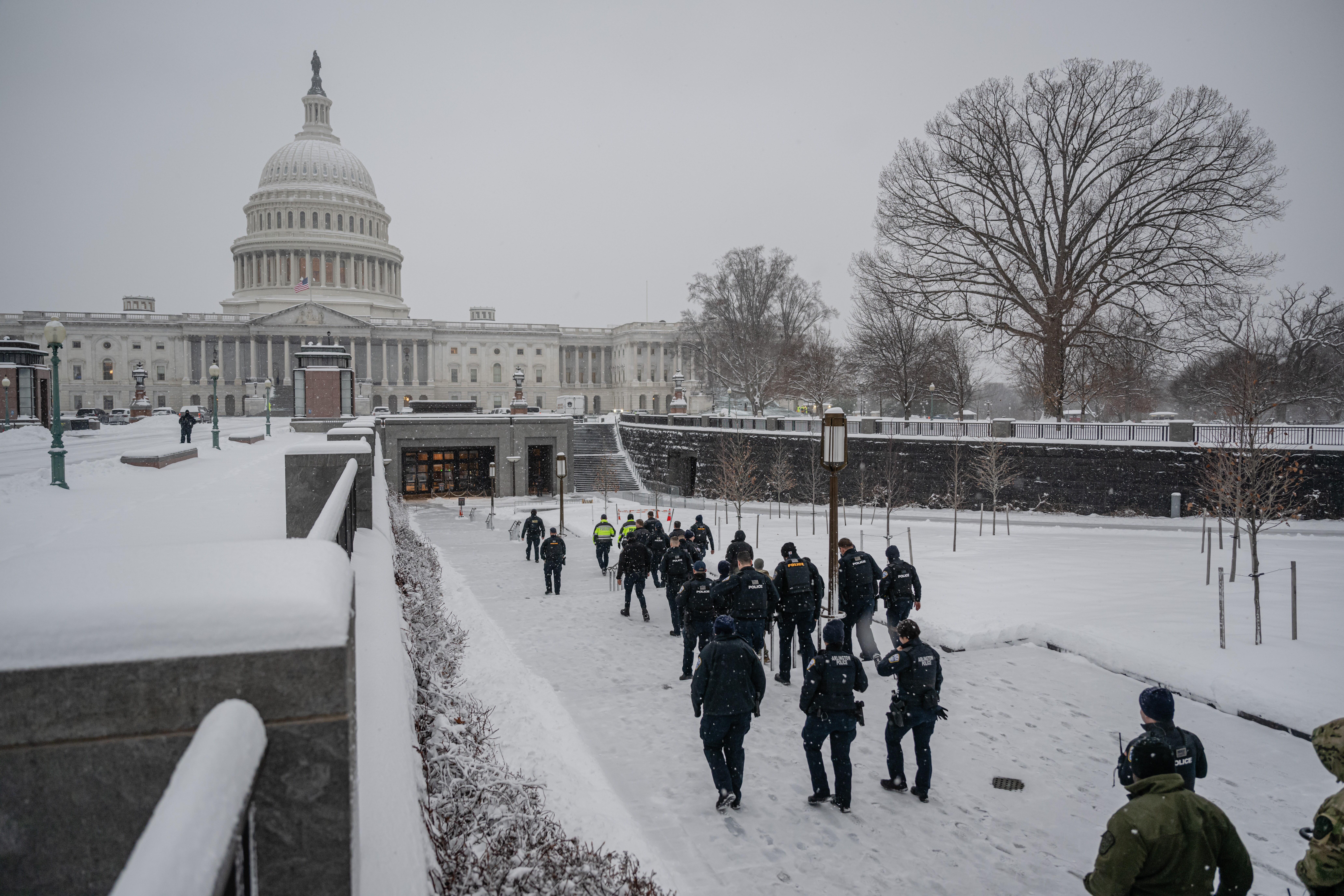 Members of law enforcement walk toward the U.S. Capitol Visitor Center entrance during Monday