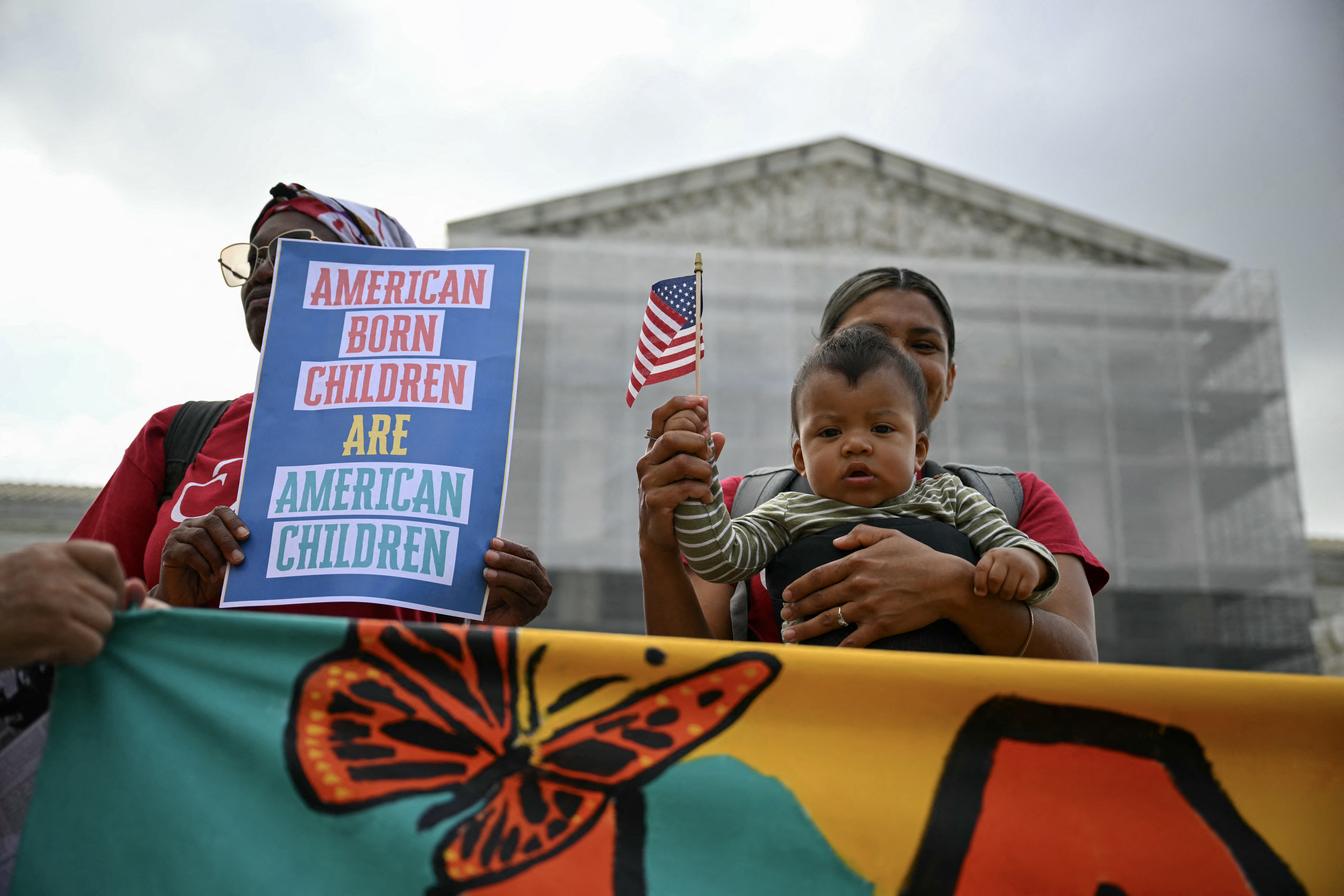 Olga Urbina holds her 9-month-old son, Ares Webster, at a protest outside the U.S. Supreme Court in Washington, DC, in May 2025.