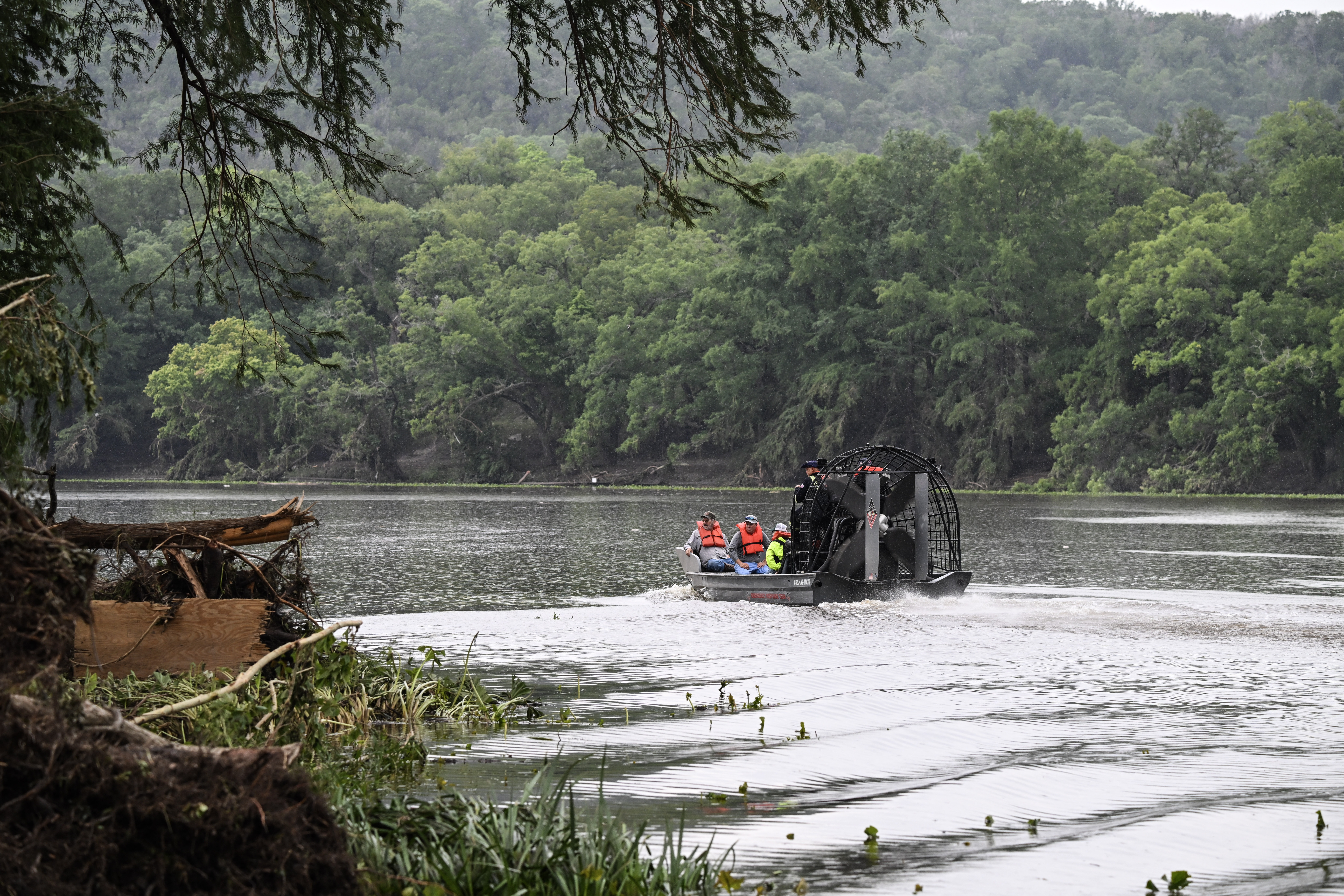 Men ride in an airboat on the Guadalupe River as they look for missing people in Hunt, Texas, on July 6, 2025, following severe flash flooding that occured during the July Fourth holiday weekend.