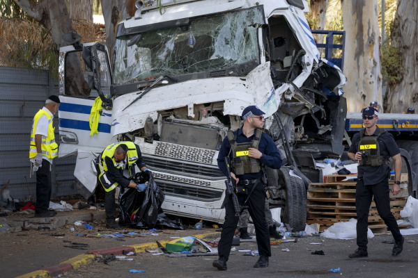 Israeli police and rescue services inspect the site where a truck driver rammed into a bus stop near an army base, wounding dozens of people, according to Israel's Magen David Adom rescue service in Ramat Hasharon, Israel, Sunday, Oct. 27, 2024.