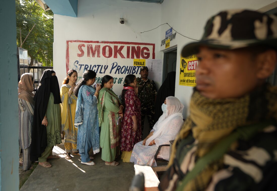 Paramilitary soldiers stand guard as people line up to vote during the first phase of the Jammu and Kashmir state assembly elections, in Kishtwar, India, Wednesday, September 18, 2024.