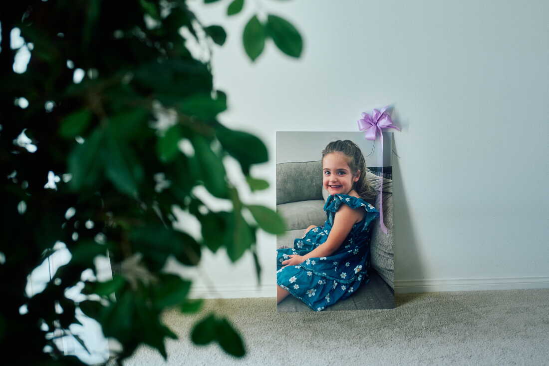 A poster of Avery, 4, that was displayed at her funeral. She smiling while wearing a dress with daisies on it.
