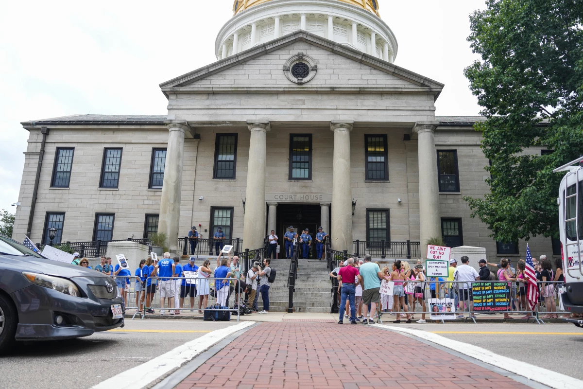 Karen Read supporters and counter-protestors, in pink and blue respectively, gather outside her July hearing at Norfolk Superior Court.