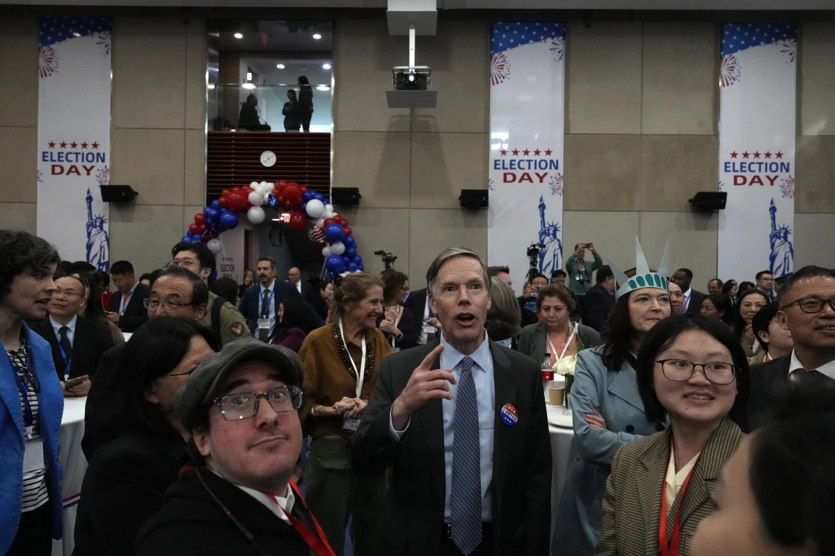 U.S. Ambassador to China Nicholas Burns watches with other attendees as voting results are displayed on screen at a reception at the U.S. Embassy in Beijing on Wednesday.
