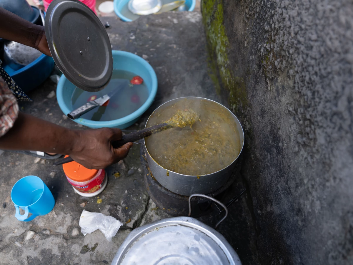 Outside Jennifer Mukuka's three-room house, where Diana now lives, Mukuka prepares a lunch of pumpkin leaves and groundnuts. Sometimes, Mukuka says, the family has only enough food to cook one meal a day of beans and a maize porridge called nshima.