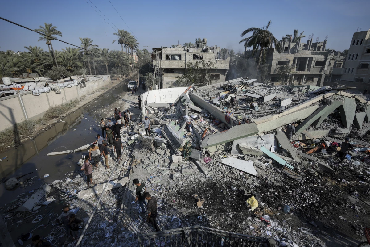 Palestinians inspect the rubble of a school destroyed in an Israeli airstrike on Deir al-Balah, central Gaza Strip, Saturday.