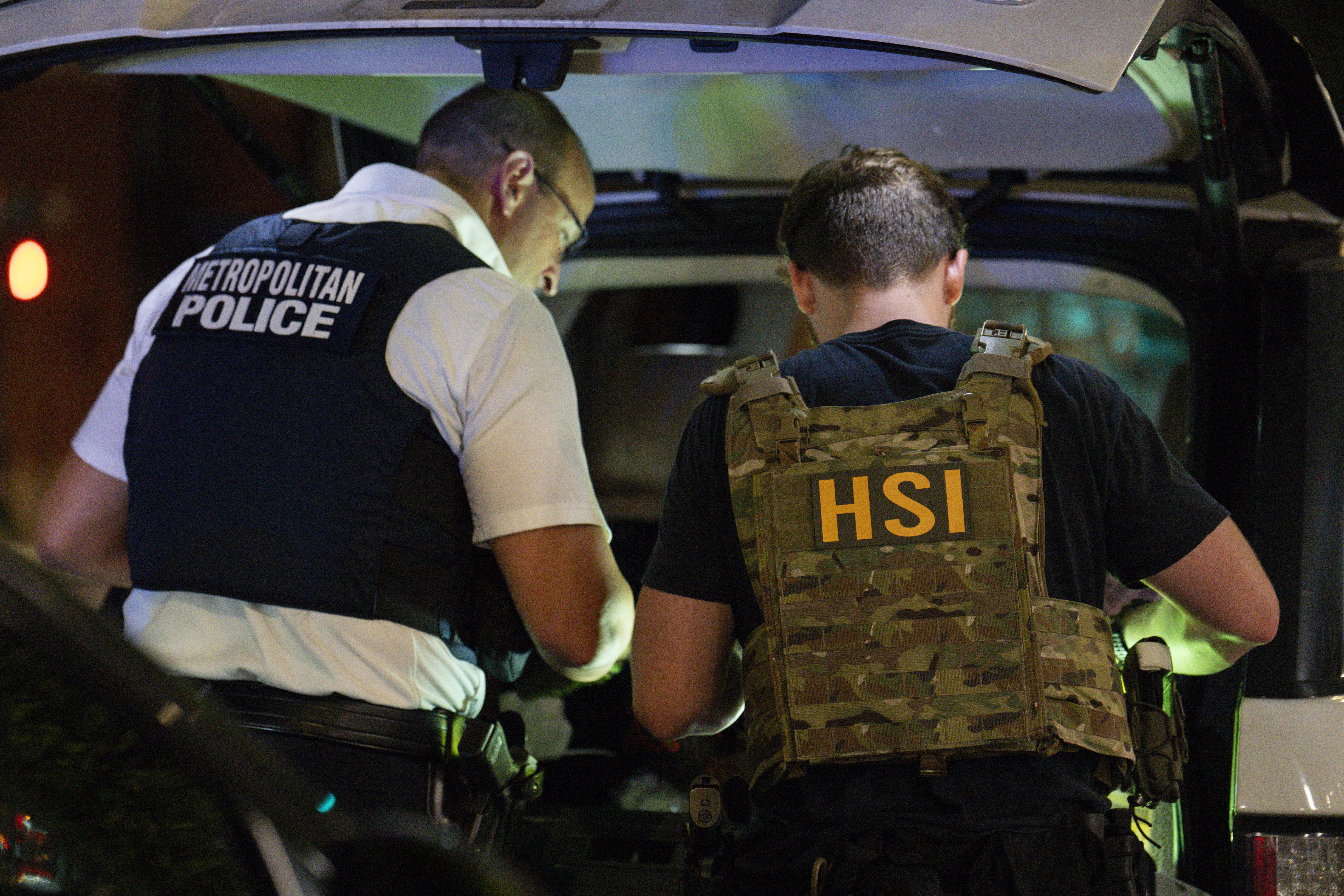 U.S. Federal Bureau of Investigation (FBI), Metropolitan Police Department (MPD), Homeland Security Investigations (HSI), and U.S. Immigration and Customs Enforcement (ICE) officers search the inside of a car during a traffic stop on Aug.14, 2025 in Washington, DC. While D.C. doesn