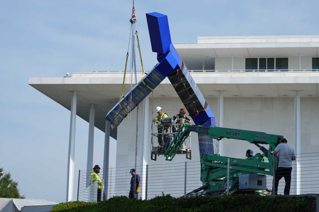 Workers remove the sculpture "Blue" by artist Joel Shapiro on the grounds of the John F. Kennedy Center for the Performing Arts in Washington, Wednesday, Sept. 2, 2026.