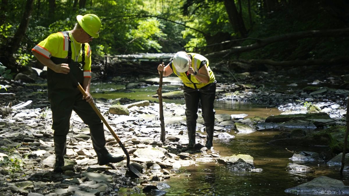 Environmental Protection Agency workers work in Leslie Run in East Palestine, Ohio on June 12, 2024.