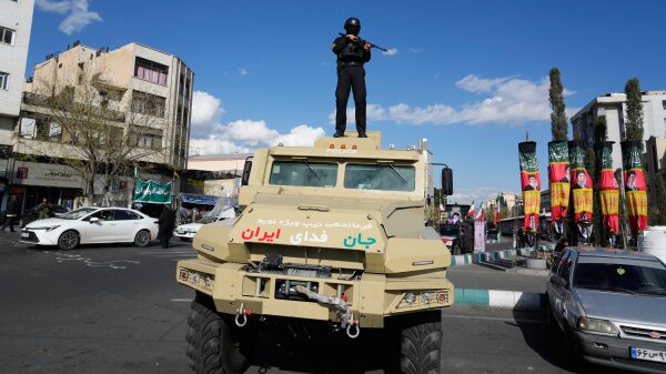 A member of police special forces stands guard on top of a vehicle in downtown Tehran Monday.