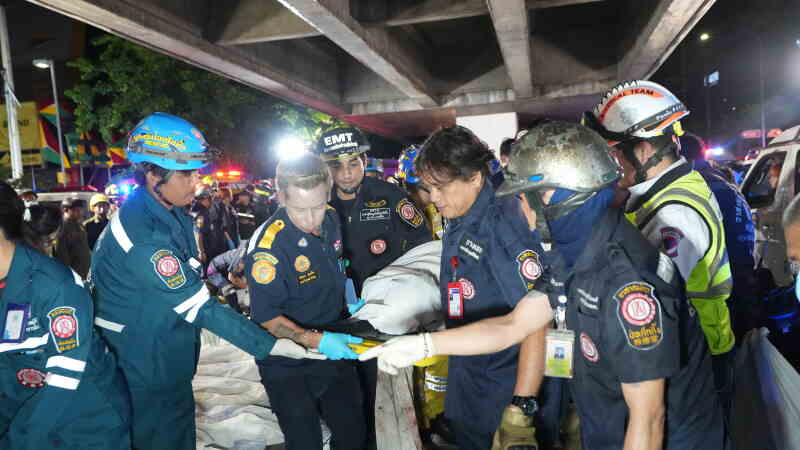 Rescuers carry the body of a victim of a fire in Bangkok, Thailand, Monday, July 13, 2026. (AP Photo/Sakchai Lalit)