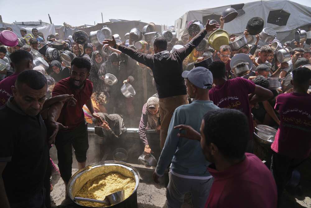 Palestinians struggle to get donated food at a community kitchen in Khan Younis, Gaza Strip on Friday, May 16. (AP)