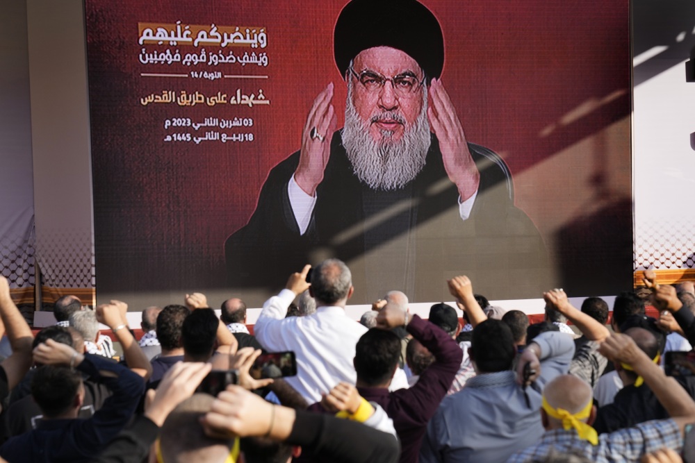 Supporters of the Iranian-backed Hezbollah group raise their fists and cheer as Hezbollah leader Hassan Nasrallah appears via a video link, during a Nov. 3, 2023, rally in Beirut to commemorate Hezbollah fighters who were killed in South Lebanon while fighting against the Israeli forces. (AP)