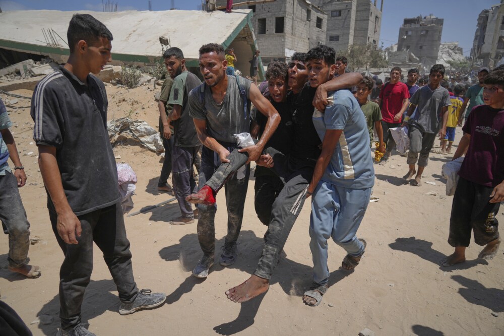 Palestinians carry a wounded man who was injured while rushing to collect humanitarian aid airdropped by parachute into Gaza City, in the northern Gaza Strip, on Aug. 7. (AP)