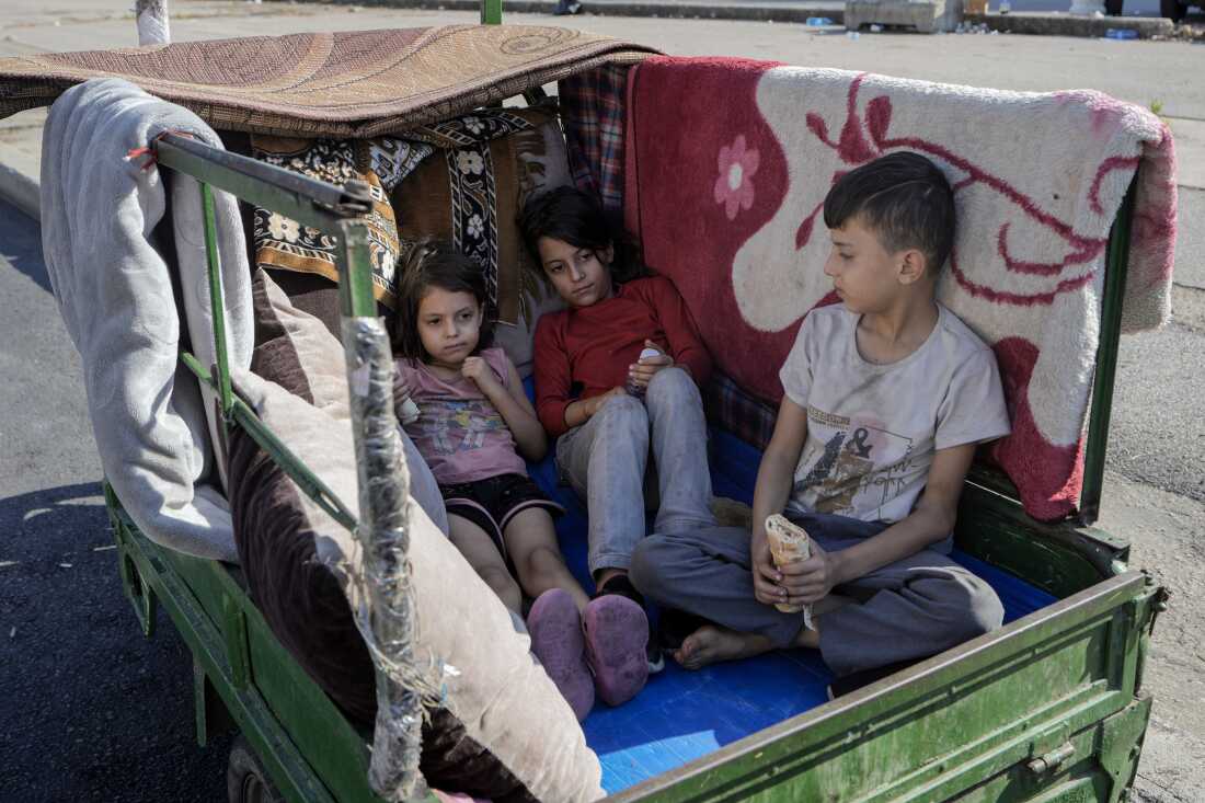 Children sit in a motorcycle cart in Beirut's Martyrs' square after fleeing the Israeli airstrikes in the southern suburbs of Dahiyeh, Sunday, Sept. 29, 2024.