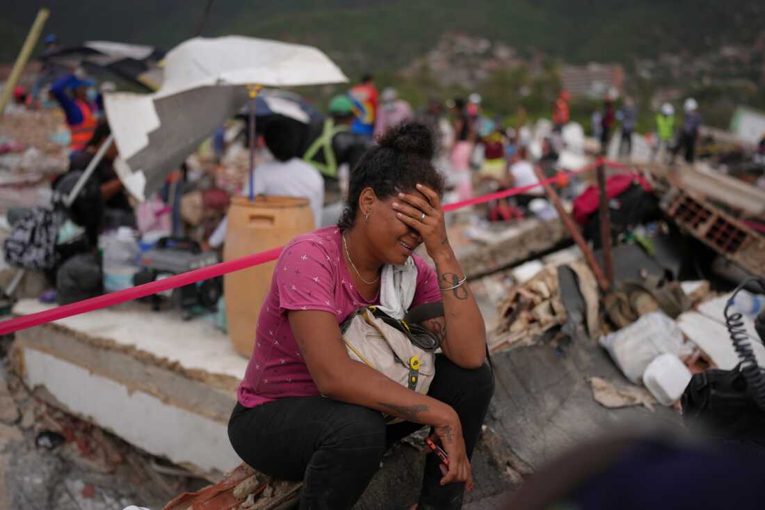 Khaterine Roa cries as members of the Los Angeles County Fire Department search for survivors at a building that collapsed during the earthquakes that struck La Guaira, Venezuela, Tuesday