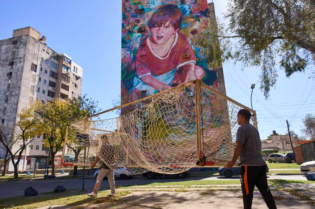 Workers from the Grandoli football club carry a goalpost to the pitch for children's soccer matches in Rosario, Argentina, 2026. (AP Photo/Rodrigo Abd)