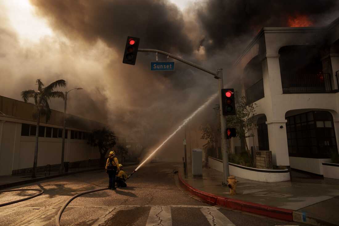 Firefighters spray flames from the Palisades Fire in Los Angeles, California. The smoke and ash from the fires spread across the city—and now residents are worried about how to clean it up safely.