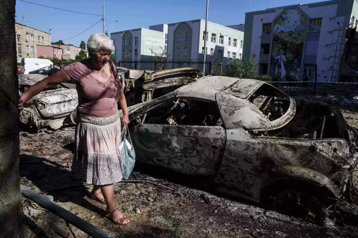 A local woman walks past cars destroyed by a Russian strike in Kyiv, Ukraine.