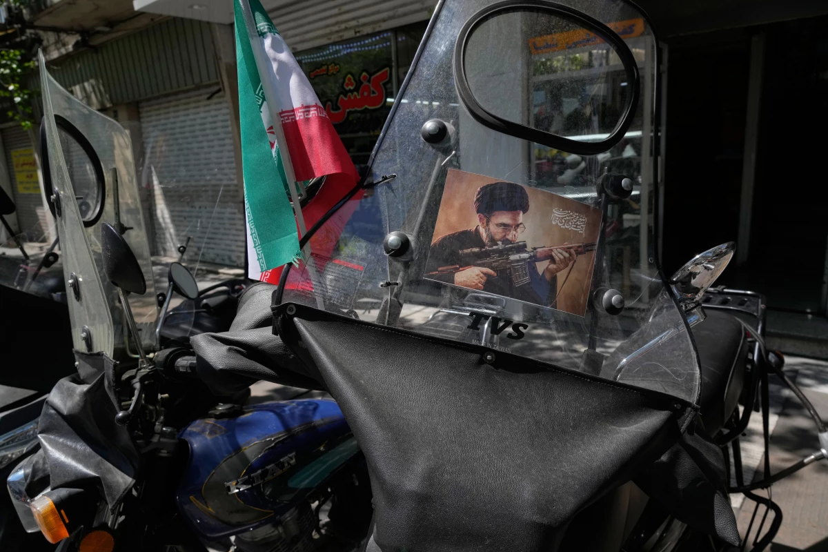 A poster is pasted on a motorbike windshield with graphic depicting Iran's Supreme Leader Ayatollah Mojtaba Khamenei as government supporters gather to mark the 40th day since the killing of his father, Supreme Leader Ayatollah Ali Khamenei, in Tehran, Iran, Thursday, April 9, 2026.