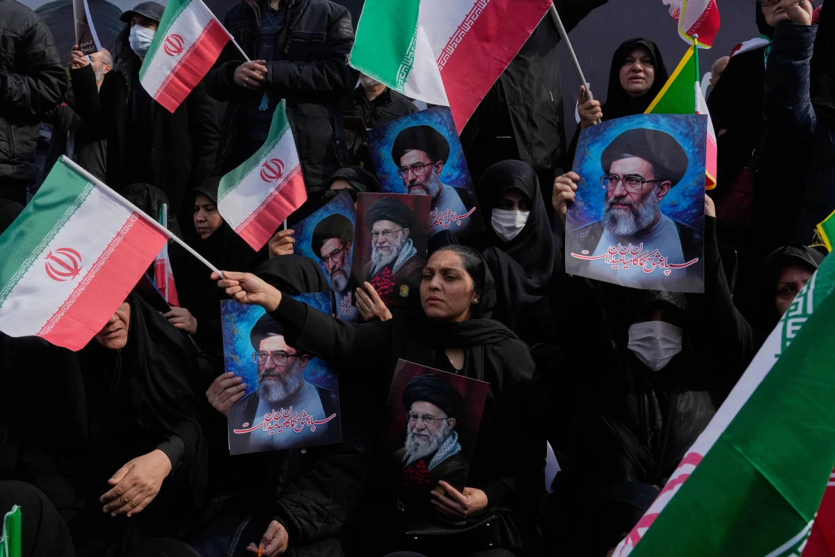 March 9: People in Tehran, Iran, wave Iranian flags as they hold posters of the late Supreme Leader Ayatollah Ali Khamenei, showing him at different ages, during a rally to support his son Mojtaba Khamenei, who succeeds his father as the new supreme leader.