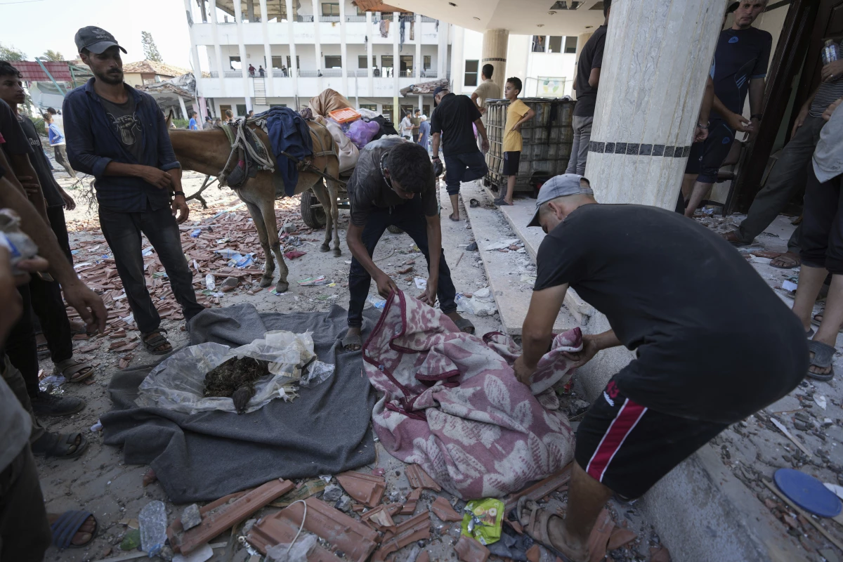 Palestinians search for bodies in the rubble of a school destroyed in an Israeli airstrike on Deir al-Balah, central Gaza Strip, Saturday.