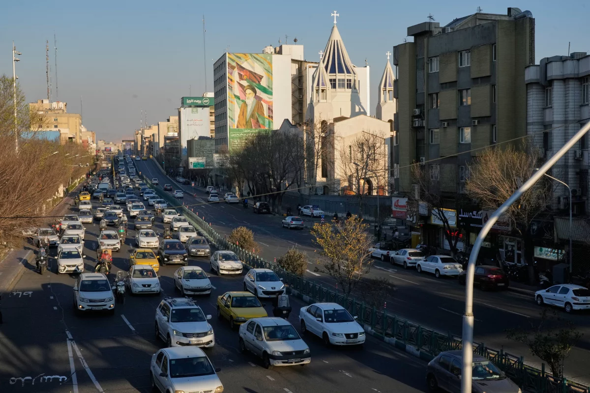 Vehicles drive past the Saint Sarkis church and a painting of the late Iranian revolutionary founder Ayatollah Khomeini in downtown Tehran, Iran, Wednesday, Feb. 25, 2026.