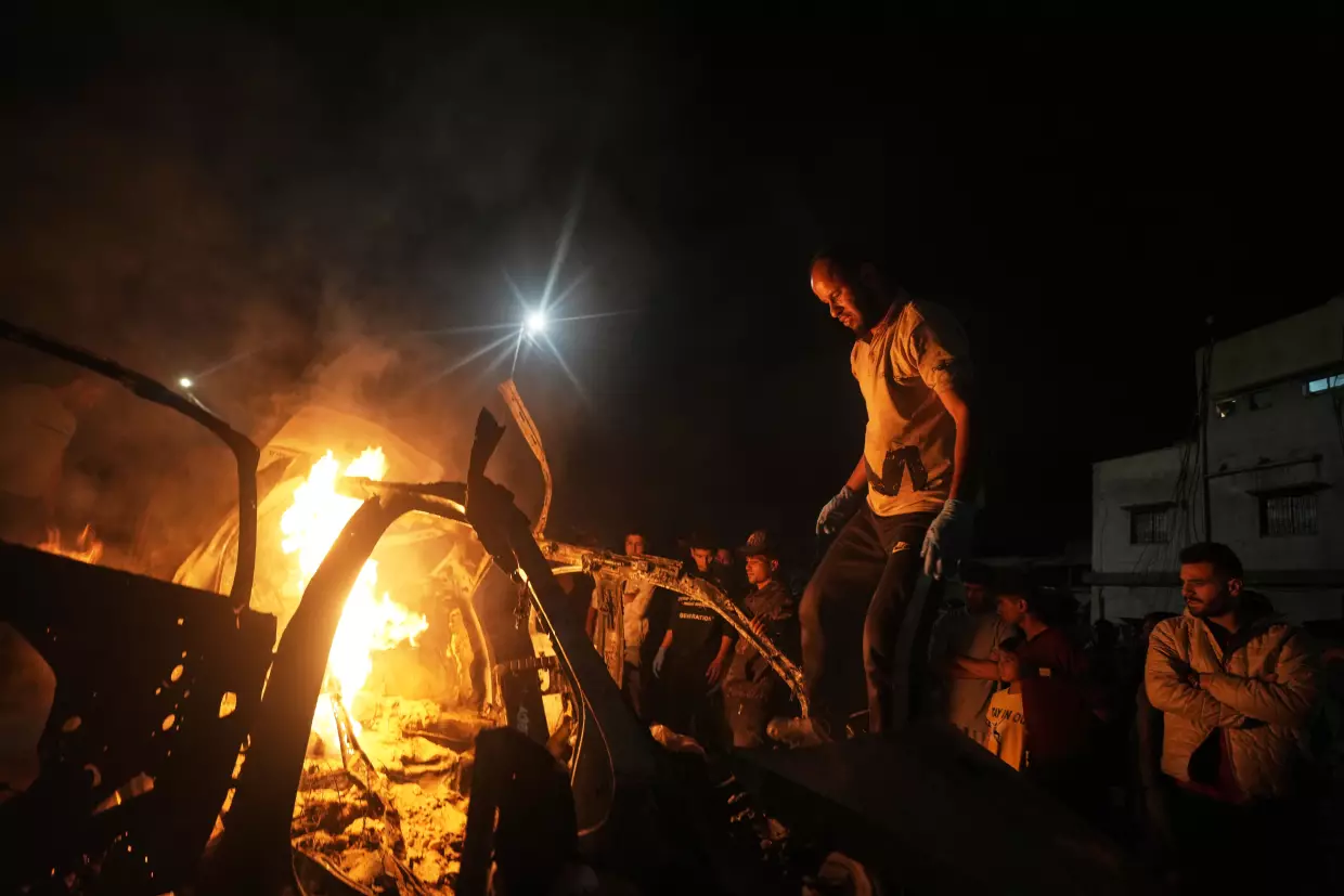 Palestinians gather around a vehicle struck by an Israeli strike in Gaza City, Friday, May 15, 2026.