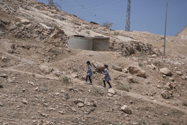 Palestinian students walk on their way home after receiving their year end reports from school, in the West Bank Bedouin hamlets of Khan al-Ahmar, Wednesday, June 10, 2026.