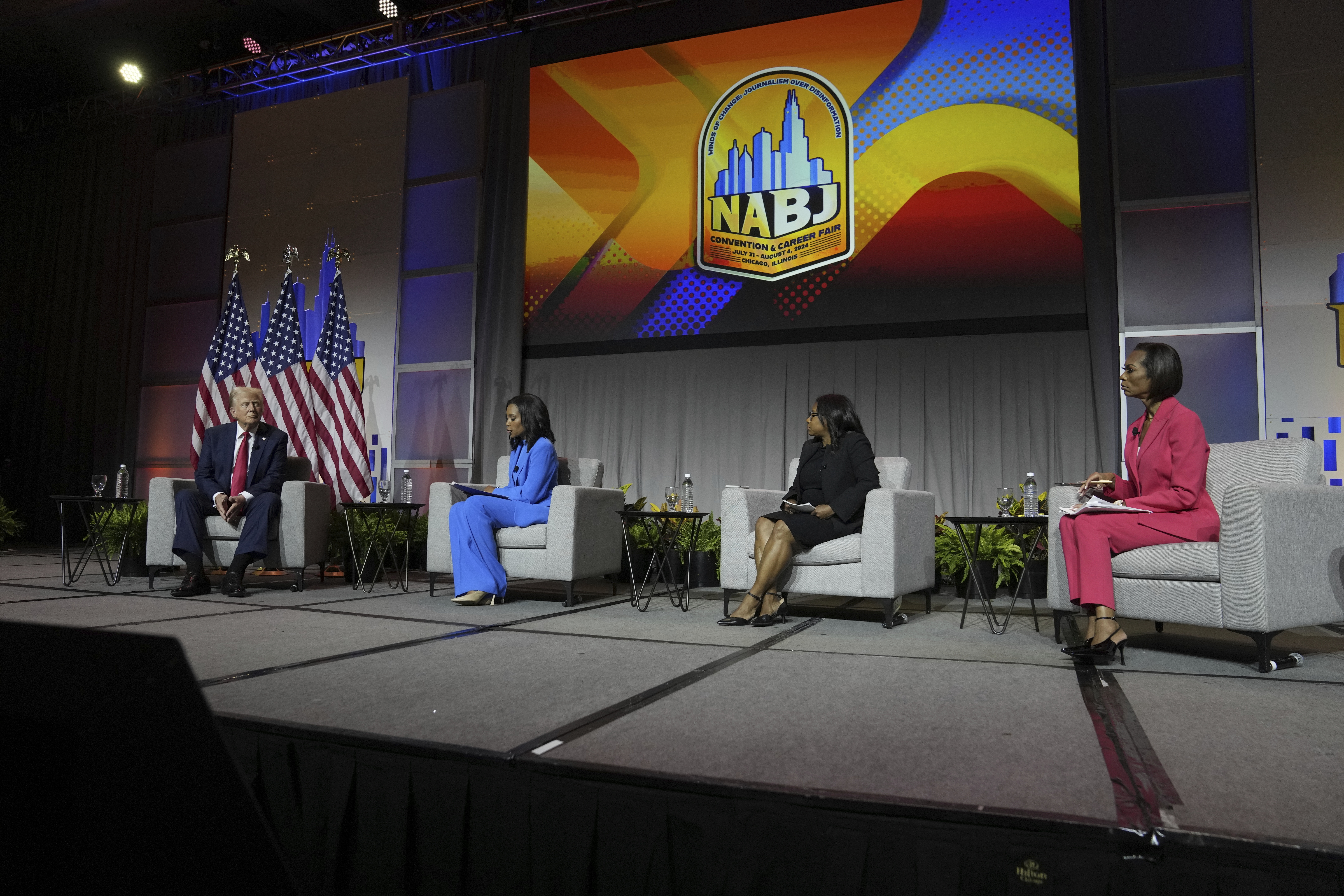 Republican presidential nominee and President Donald Trump speaks at a panel moderated by, from left, ABC's Rachel Scott, Semafor's Kadia Goba and Fox News' Harris Faulkner at the National Association of Black Journalists convention Wednesday in Chicago. (AP)