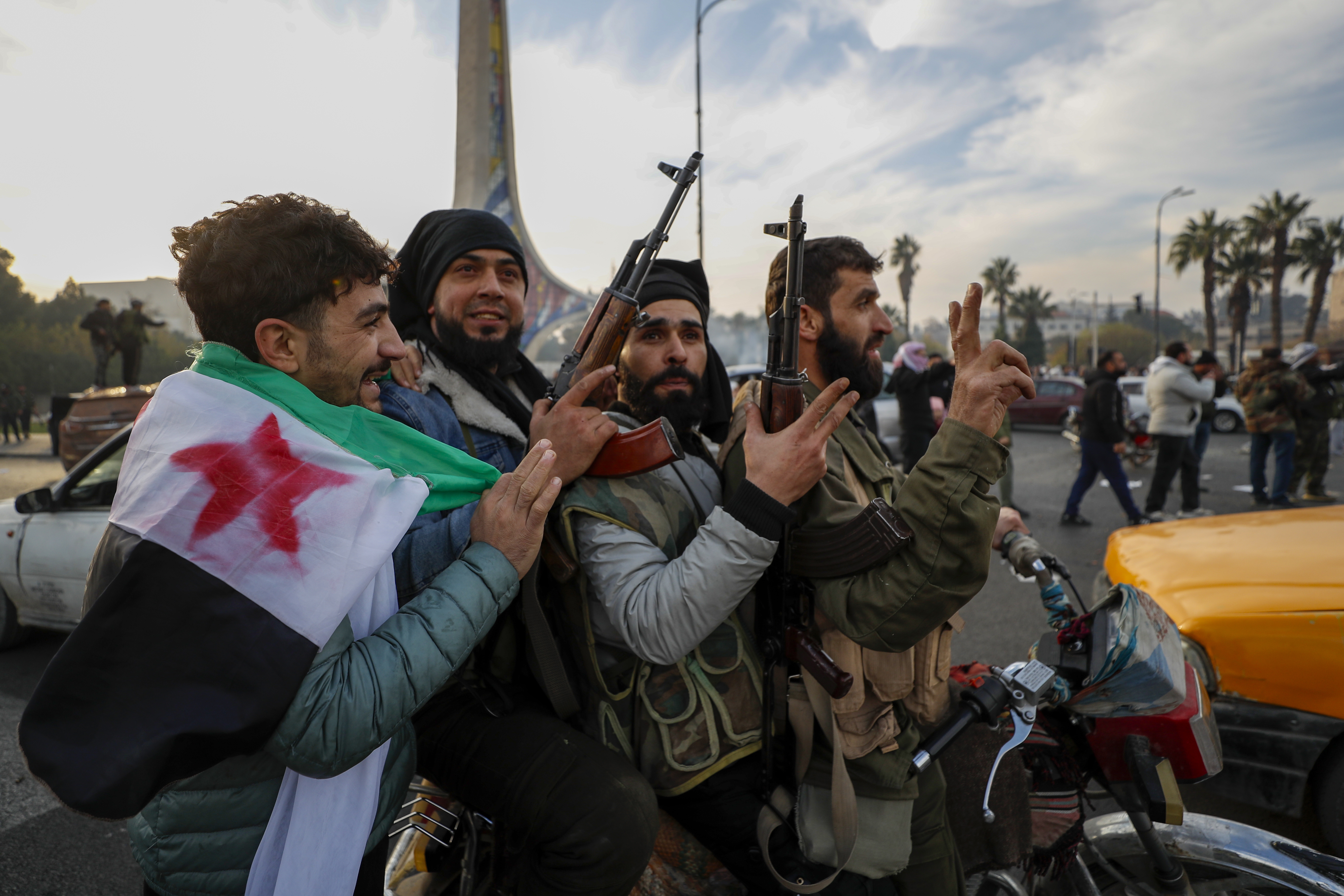 Syrian opposition fighters celebrate after the Syrian government collapsed in Damascus, Syria, Sunday, Dec. 8, 2024.