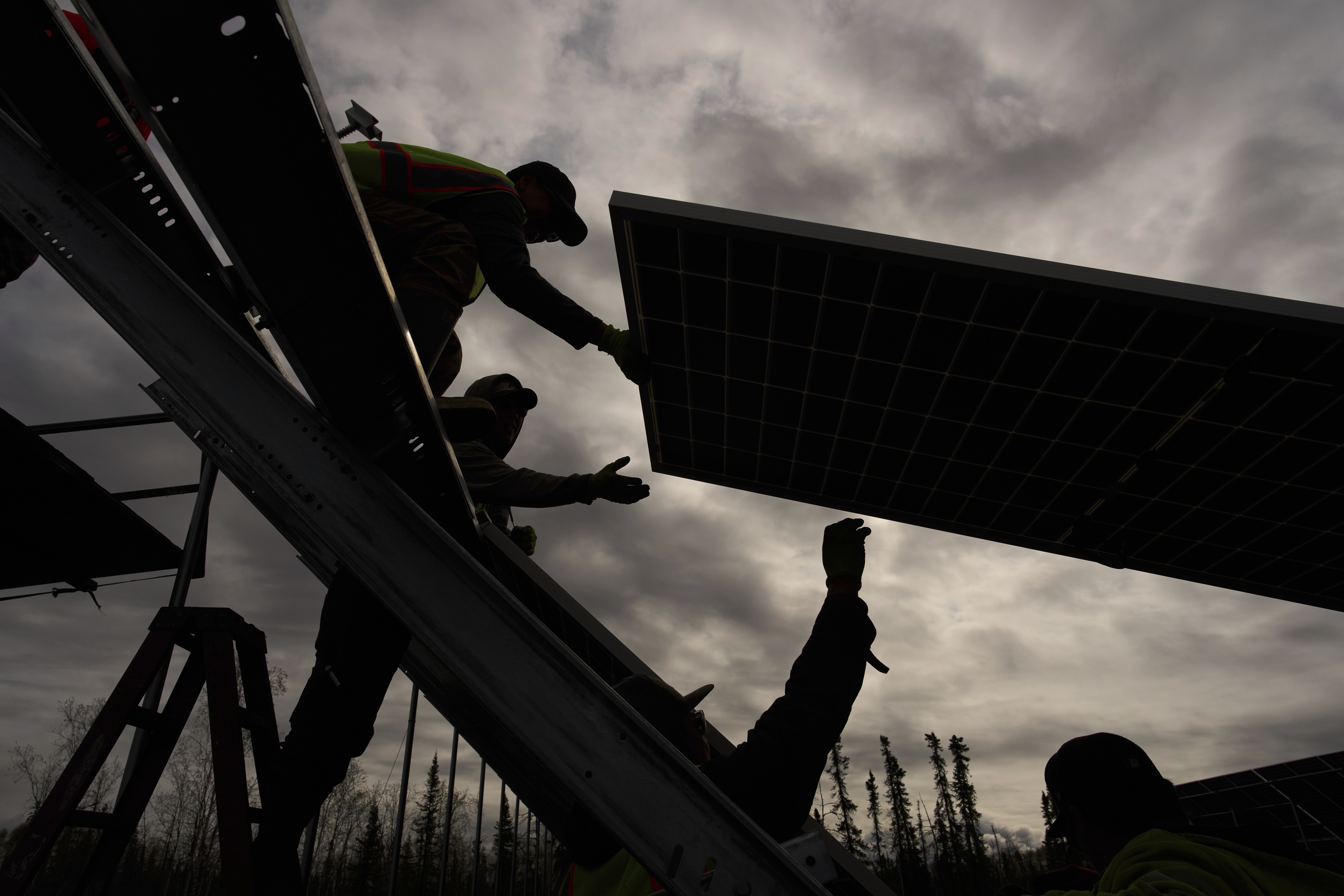 Workers install solar panels at a project this spring in Galena, Alaska.