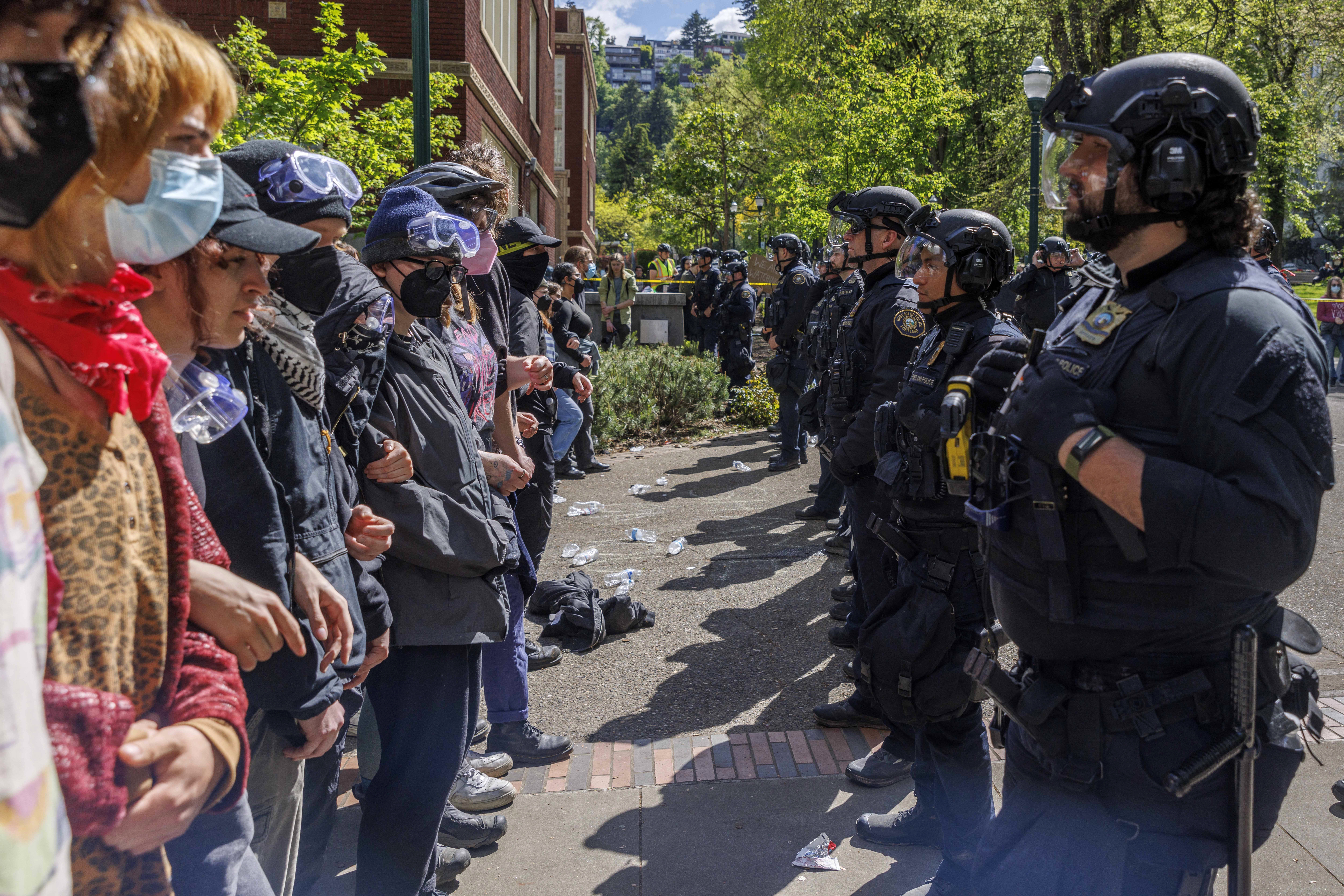 Pro-Palestinian students and activists face police officers after protesters were evicted from the library at Portland State University in Portland, Ore., in May. (AFP via Getty Images)
