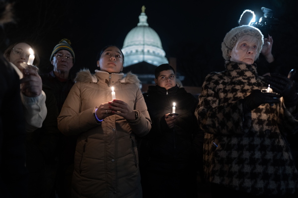 People attend a vigil on the grounds of the Wisconsin State Capitol building to mourn the victims of the shooting at Abundant Life Christian School in Madison, Wis.