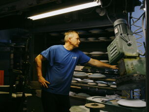 Pickard China's David Nosko stand by one of the factory's hulking, noisy, clay-splattered machines.