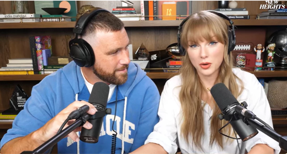 Travis Kelce looks at Taylor Swift during Wednesday's episode of New Heights, the podcast he cohosts with his brother Jason Kelce.