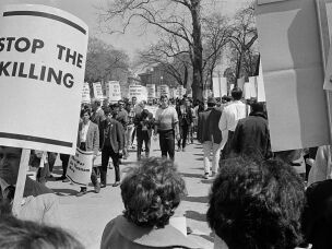 Demonstrators carrying signs against the war in Vietnam march in front of the White House in April 1965 in Washington, D.C.