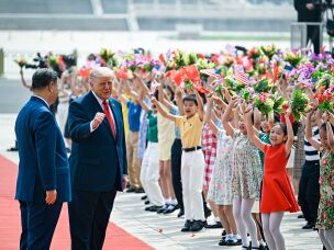President Trump and China's President Xi Jinping (left) greet children waving Chinese and U.S. flags and flowers during a welcome ceremony at the Great Hall of the People in Beijing on Thursday.