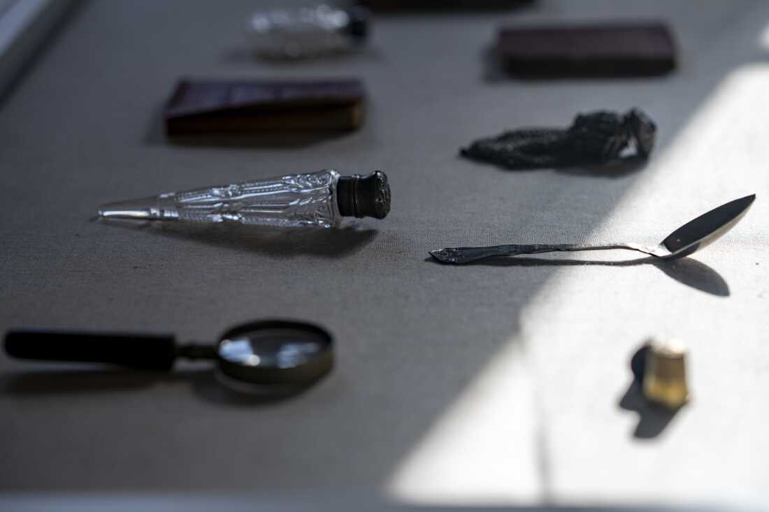 A display case holds items that were once owned by African American residents of New York City's tenements. They include a spoon, a magnifying glass and a collection of Abraham Lincoln's speeches.