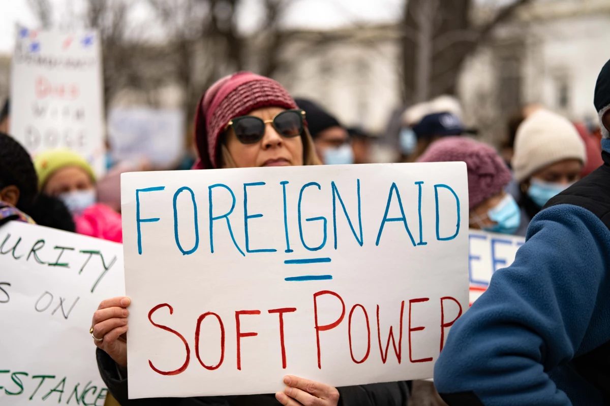 A protester carries a sign that equates foreign aid with soft power during a rally near the U.S. Capitol to protest the dismantling of USAID, the international agency charged with dispensing humanitarian aid around the world on behalf of the United States.