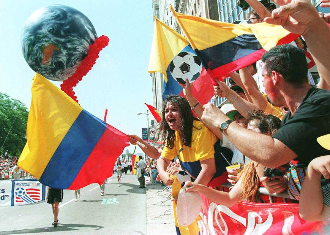 Standing along the side of a street, Colombian soccer fans wave their country's flag during the "Chicago Welcomes the World Cup" parade on June 15, 1994.