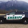 A King County Sheriff's Office car is shown with mountains in the background.