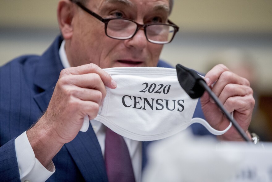 Census Bureau Director Steven Dillingham holds up his mask with the words "2020 Census" as he testifies before a House Committee on Oversight and Reform hearing on the census in July.
