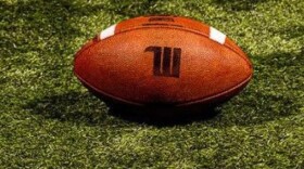 a football placed on a field, with a Wittenberg logo on it