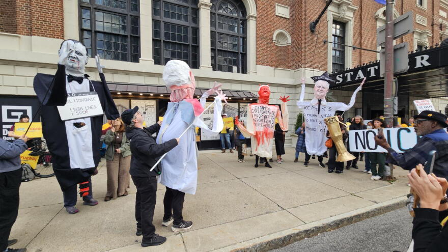 Protesters use several oversized puppets of real estate executive Carl Montante to act out a skit describing their criticisms of Montante, namely renting out offices to ICE