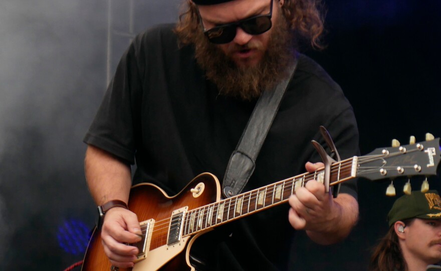 Jason Richard plays guitar on stage at Moon River 2022.