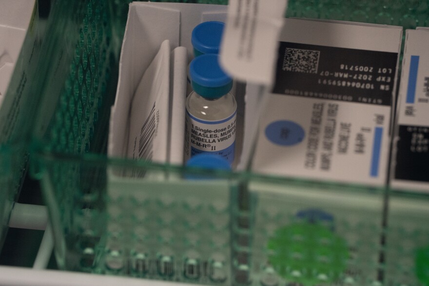 Vials of the combination measles, mumps and rubella vaccine are seen in a fridge.