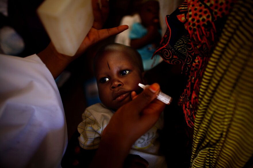 At the health clinic in Minjibir, two drops of vaccine are dropped into a child's mouth during a 2012 campaign.